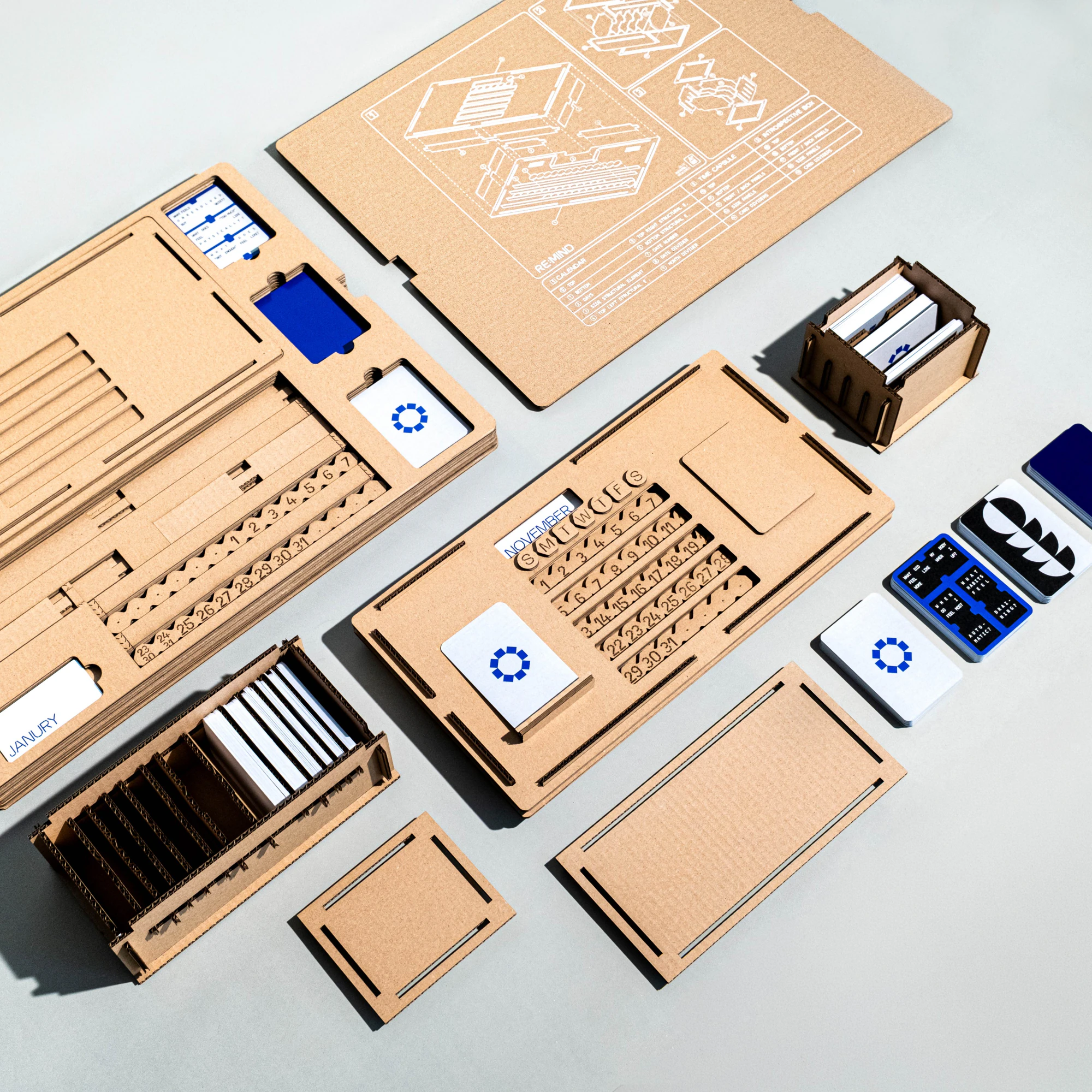 RE:MIND cardboard calendar, card boxes and packaging components arranged together