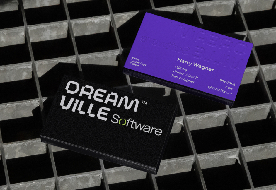 Black and purple Dream Ville Software business cards on a metal grid